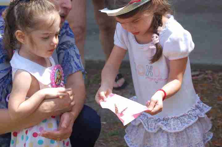 A young girl carefully releasing a butterfly from butterfly release package