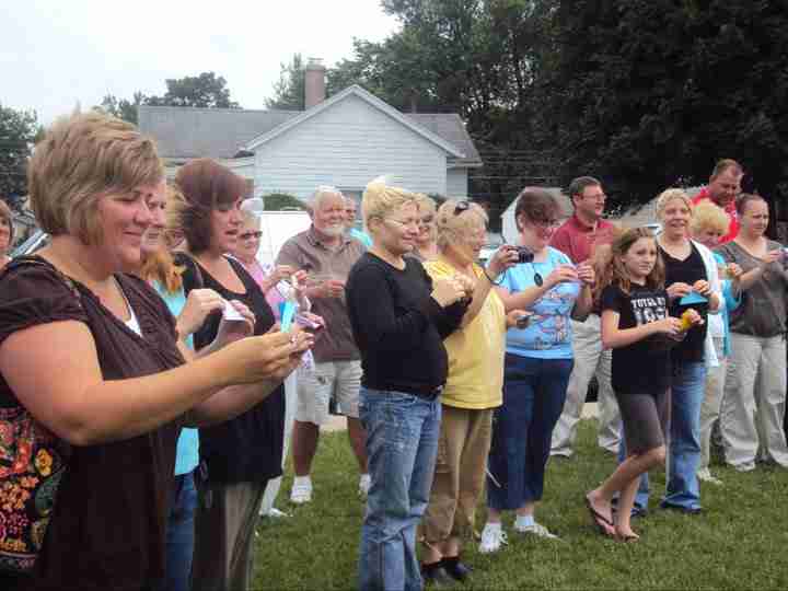 A group of adults releasing butterflies at outdoor event